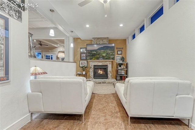 living room featuring ceiling fan and a fireplace