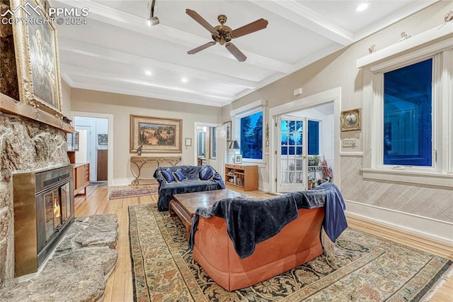 living room with beam ceiling, light hardwood / wood-style flooring, ceiling fan, and a premium fireplace