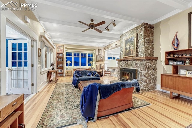 living room with ceiling fan, beam ceiling, light hardwood / wood-style floors, and a fireplace