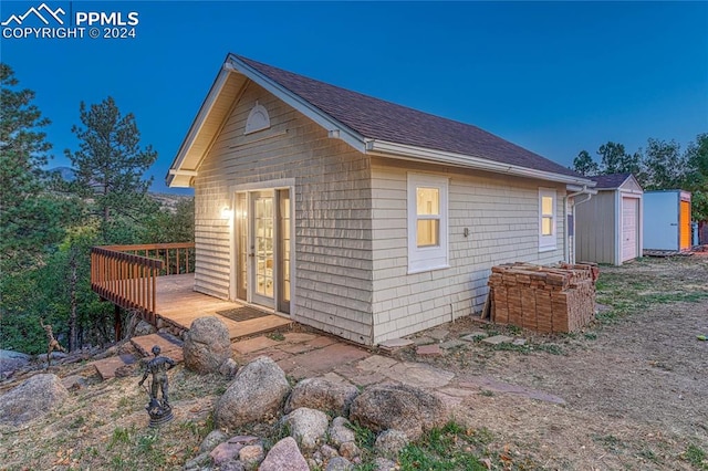 view of home's exterior featuring a storage shed and a wooden deck