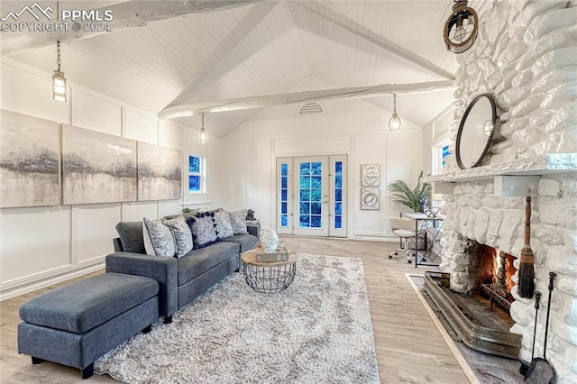 living room with a fireplace, beamed ceiling, light hardwood / wood-style floors, and high vaulted ceiling