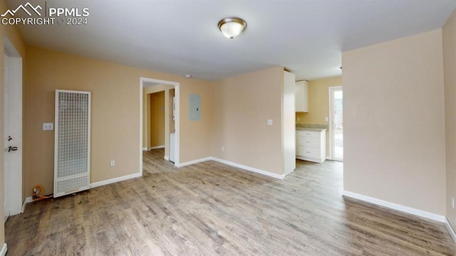 empty room featuring electric panel and light wood-type flooring