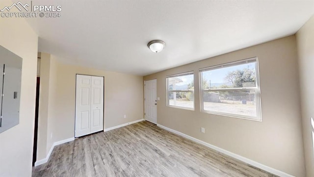 unfurnished bedroom featuring a closet and light wood-type flooring