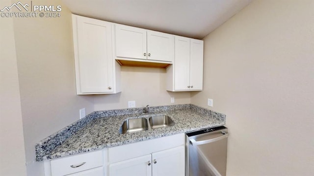 kitchen with white cabinetry, stainless steel dishwasher, and sink