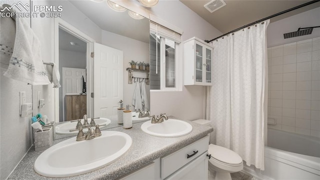 full bathroom with vanity, shower / bath combo with shower curtain, and toilet