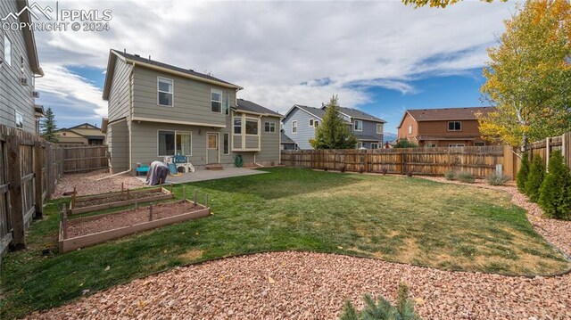 rear view of property featuring a patio and a yard