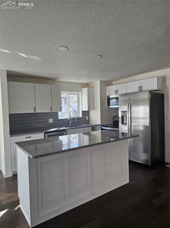 kitchen featuring white cabinetry, a kitchen island, and appliances with stainless steel finishes