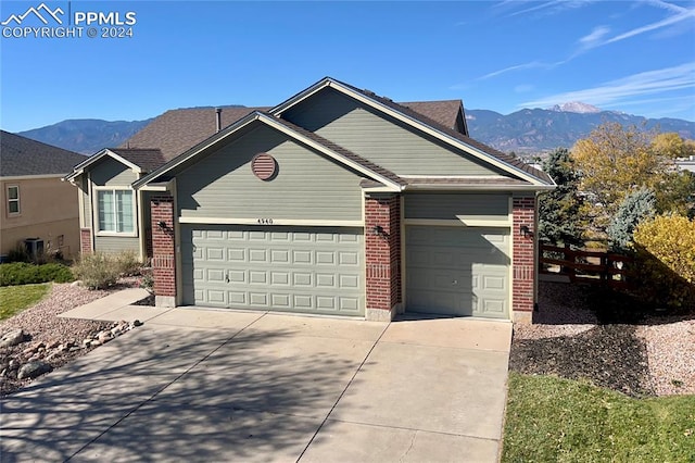 ranch-style house featuring a garage and a mountain view