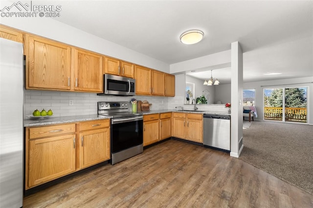 kitchen with stainless steel appliances, dark wood-type flooring, sink, and backsplash