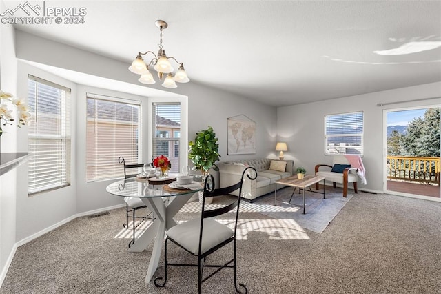 carpeted dining room with a notable chandelier