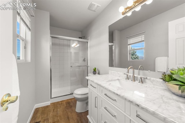 bathroom featuring hardwood / wood-style floors, vanity, toilet, and an enclosed shower