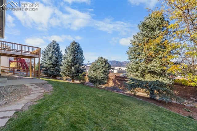 view of yard with a deck with mountain view