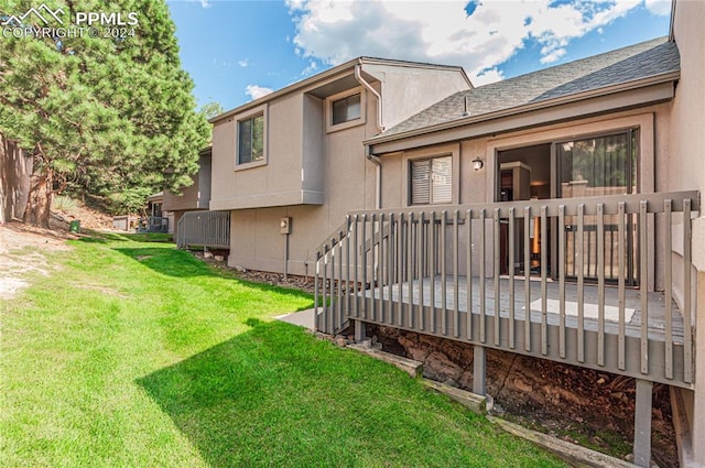 back of house with a yard and a deck