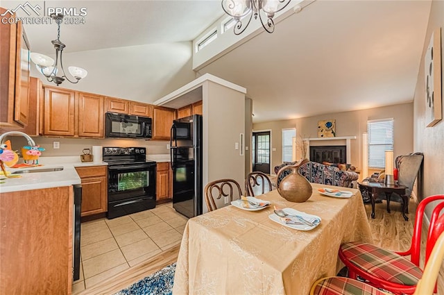 kitchen featuring lofted ceiling, sink, black appliances, decorative light fixtures, and an inviting chandelier