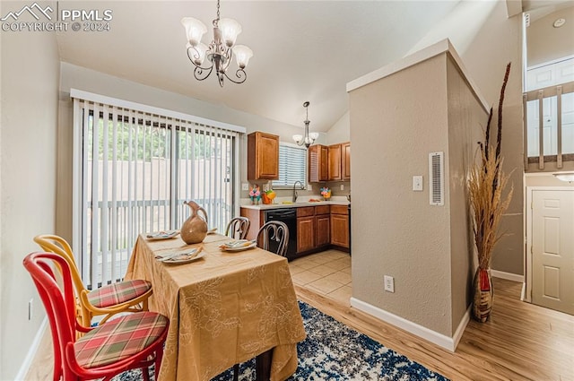 dining space featuring light hardwood / wood-style flooring, a chandelier, and lofted ceiling