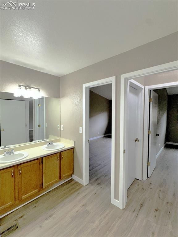 bathroom with vanity, a textured ceiling, and hardwood / wood-style floors