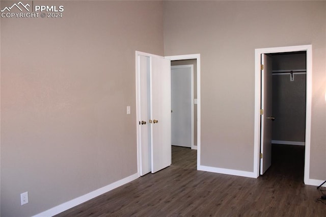 unfurnished bedroom featuring a closet and dark wood-type flooring