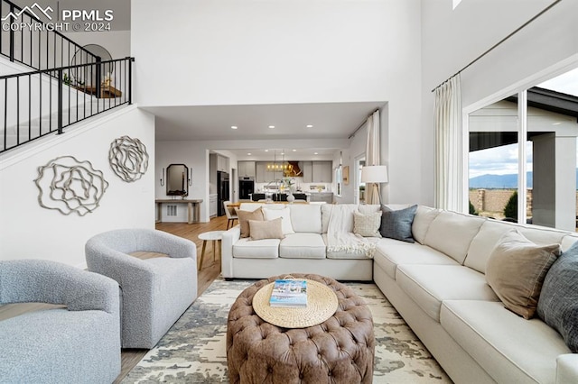 living room featuring light hardwood / wood-style flooring and a towering ceiling