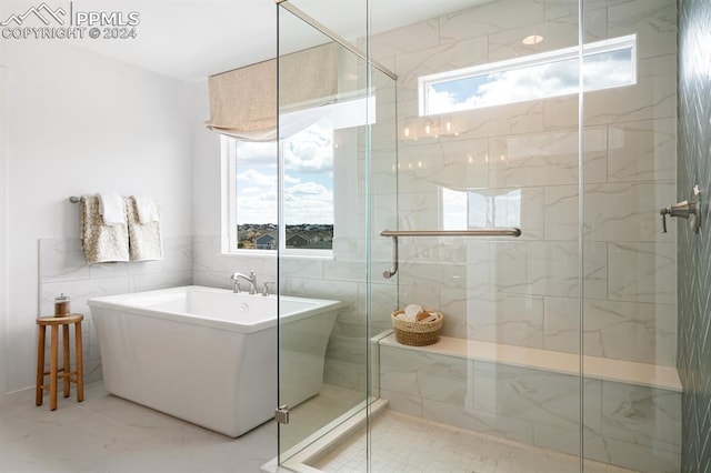 bathroom with tile walls and separate shower and tub