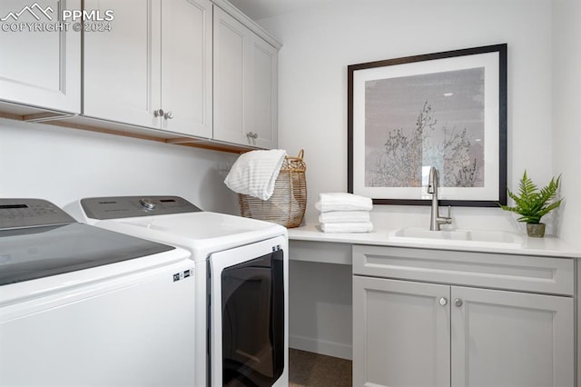 laundry area with washing machine and dryer, sink, and cabinets