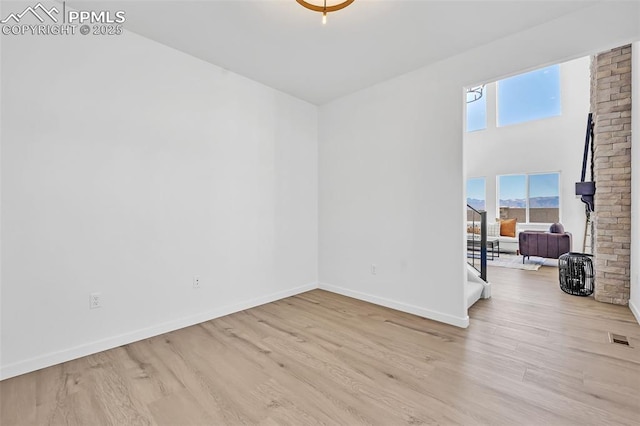 8542 Noreen Falls Dr, Colorado Springs, CO 80924 - empty room featuring wood finished floors, baseboards, stairway, and a towering ceiling