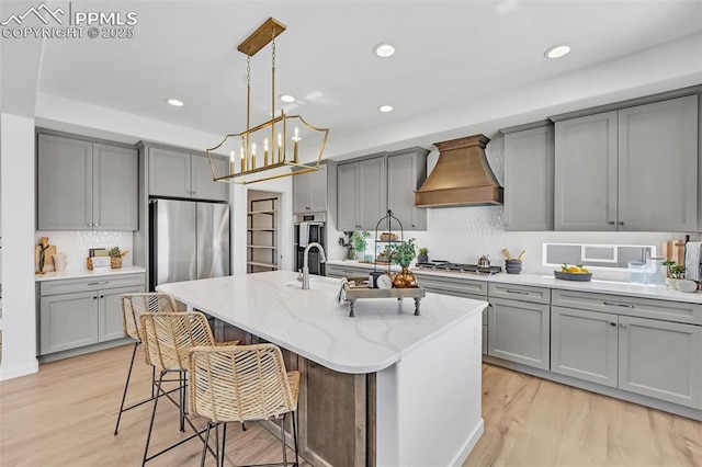 8542 Noreen Falls Dr, Colorado Springs, CO 80924 - kitchen with gray cabinetry, custom exhaust hood, appliances with stainless steel finishes, and recessed lighting