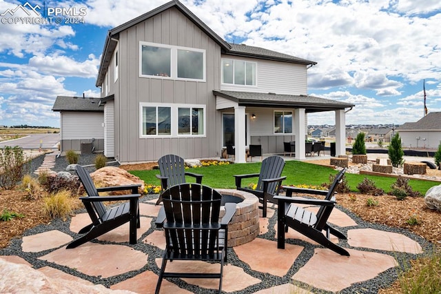 rear view of property with central air condition unit, a patio area, a yard, and a fire pit