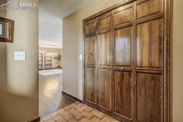 corridor featuring a chandelier and light hardwood / wood-style floors