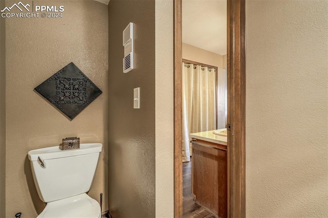 bathroom with vanity, toilet, and hardwood / wood-style flooring