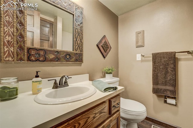 bathroom featuring vanity, toilet, and wood-type flooring