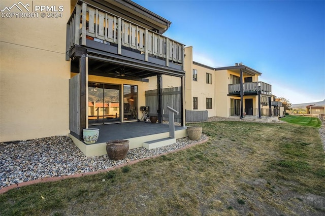 back of property with a balcony and a lawn