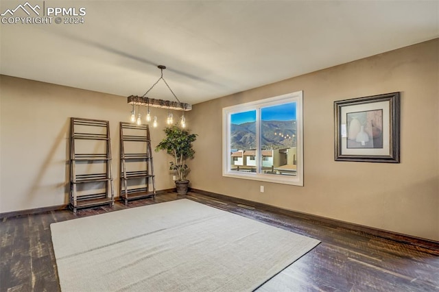 unfurnished dining area with a chandelier and dark hardwood / wood-style floors