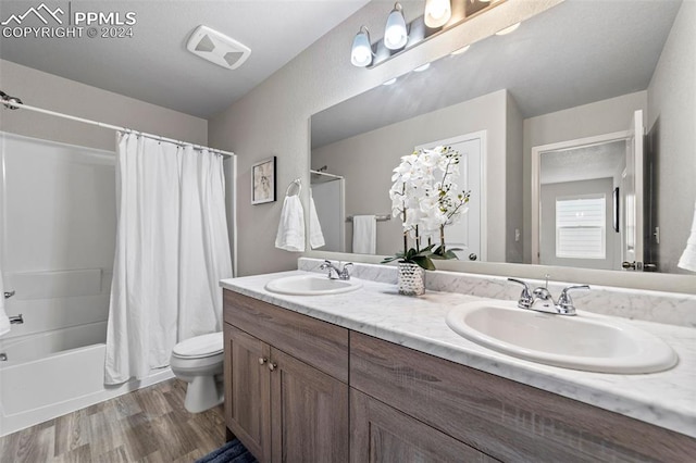 full bathroom with vanity, toilet, hardwood / wood-style flooring, and shower / bath combo