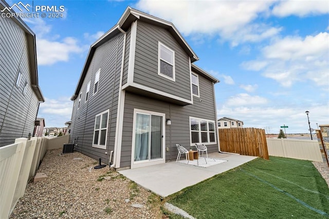 rear view of property featuring a patio, a yard, and central air condition unit