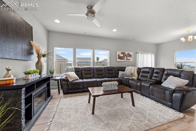 living room featuring light hardwood / wood-style floors and ceiling fan with notable chandelier