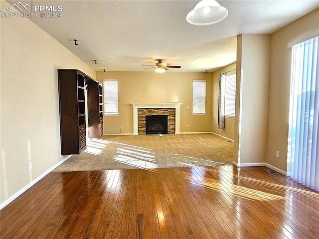 unfurnished living room featuring light hardwood / wood-style flooring, a fireplace, and ceiling fan