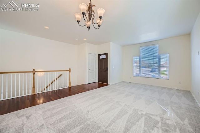 unfurnished room with a notable chandelier and hardwood / wood-style flooring