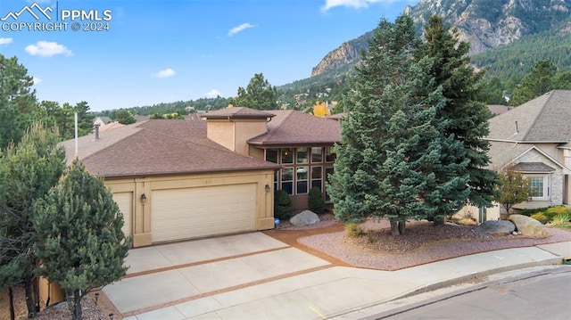 view of front of property with a garage and a mountain view