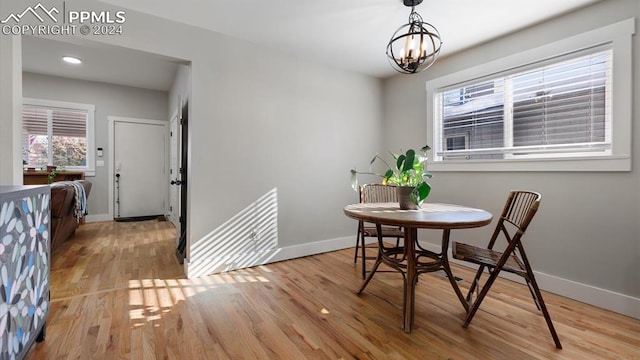 dining space with light hardwood / wood-style flooring and a notable chandelier