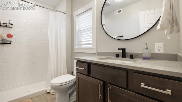 bathroom featuring tile patterned floors, curtained shower, vanity, and toilet