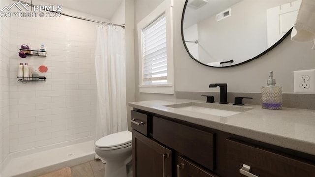 bathroom featuring a shower with shower curtain, vanity, toilet, and tile patterned flooring