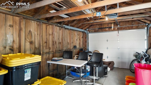 garage with wooden walls and a garage door opener