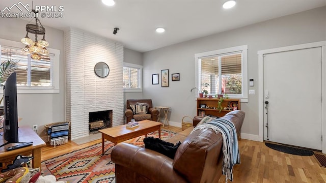 living room featuring a stone fireplace and light wood-type flooring