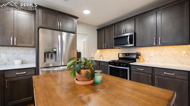 kitchen with dark brown cabinetry, appliances with stainless steel finishes, and tasteful backsplash