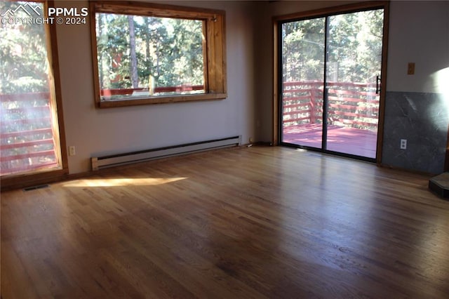 spare room featuring a baseboard radiator and dark hardwood / wood-style flooring