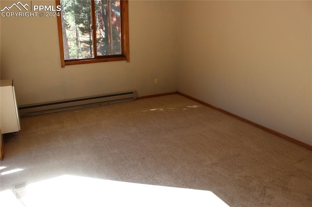 unfurnished room with a baseboard heating unit and carpet floors