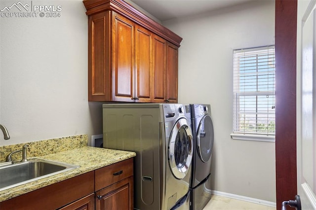 clothes washing area featuring cabinet space, independent washer and dryer, baseboards, and a sink