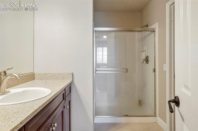 full bath with baseboards, a shower stall, and vanity