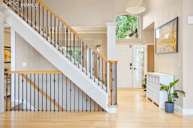 foyer entrance featuring wood finished floors, baseboards, a high ceiling, and stairway