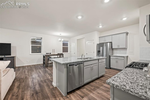 kitchen featuring stainless steel appliances, sink, pendant lighting, and dark hardwood / wood-style floors